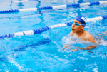 A young boy comes up for a breath as he swims down the lane of a pool